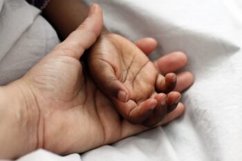 genitore che stringe le mani del figlio 